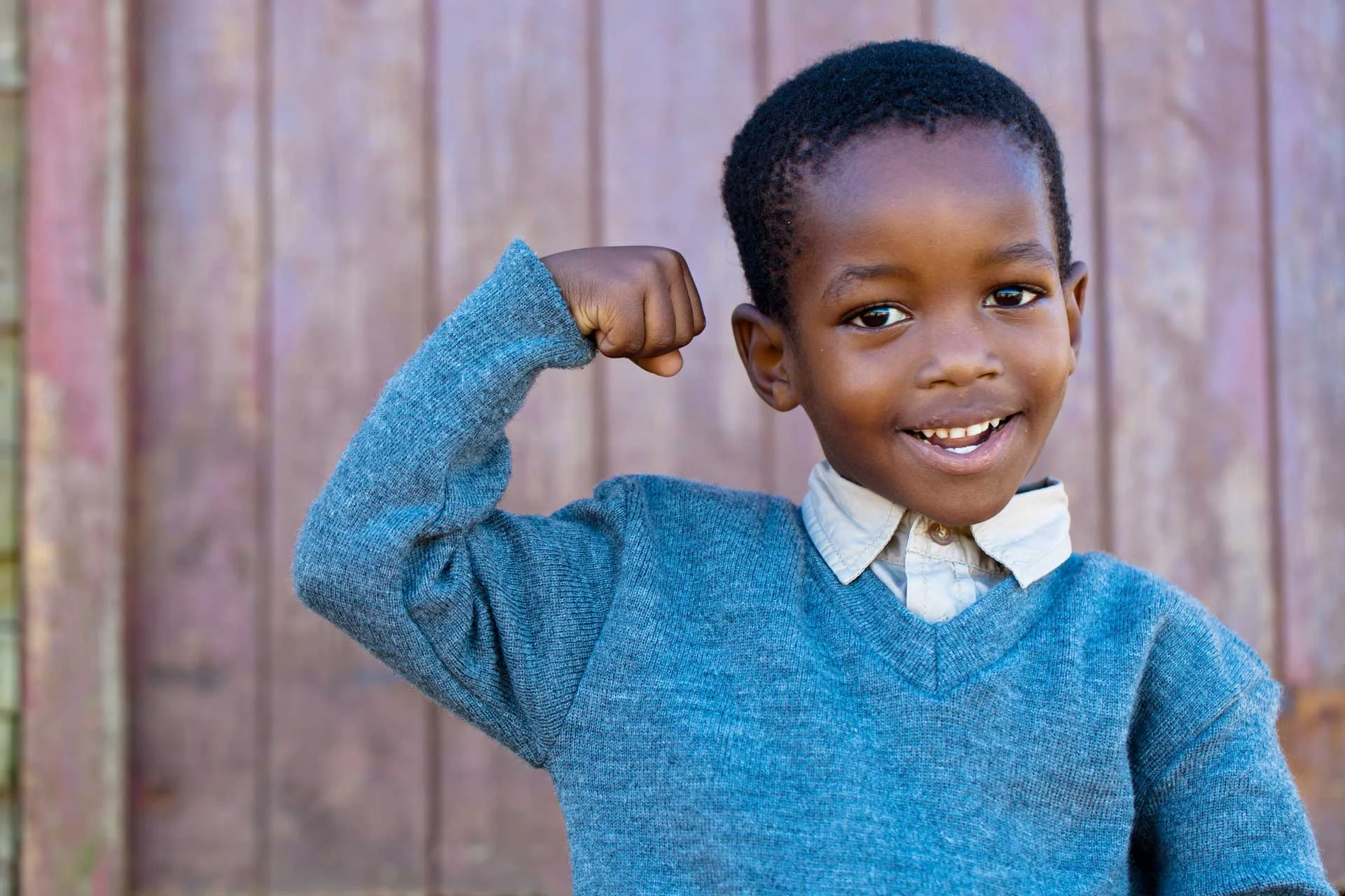 young-boy-smiling-while-flexing-his-arm.jpg