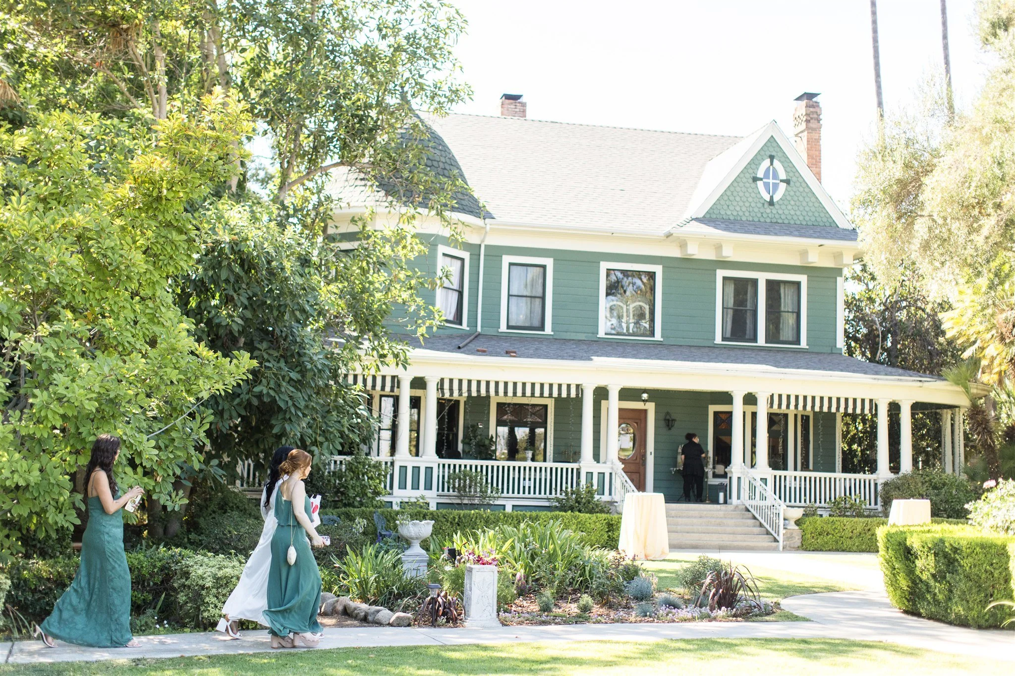 Wedding guests arriving at the front garden entrance of The Christmas House, a historic garden wedding venue