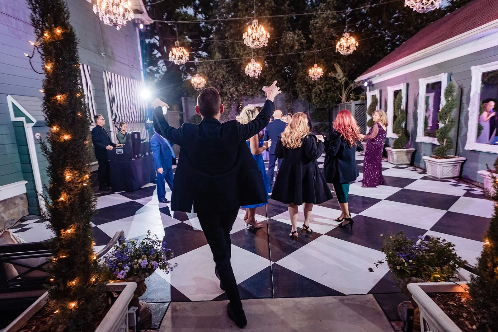 guest walking onto black and white checkered dance floor ready to celebrate at the Christmas House Inn and Gardens