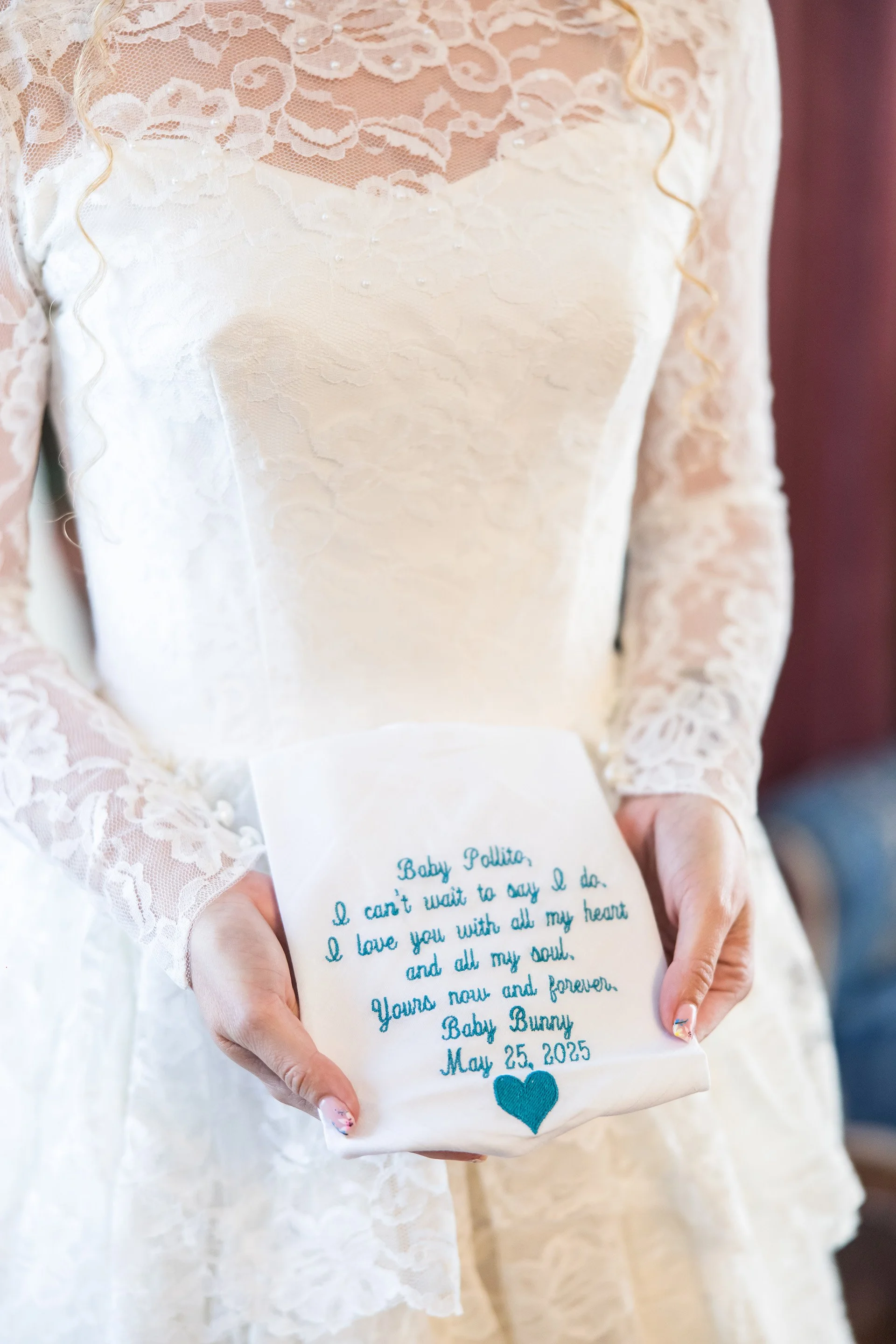 Bride holding an embroidered handkerchief with a love note to her future spouse during her wedding day
