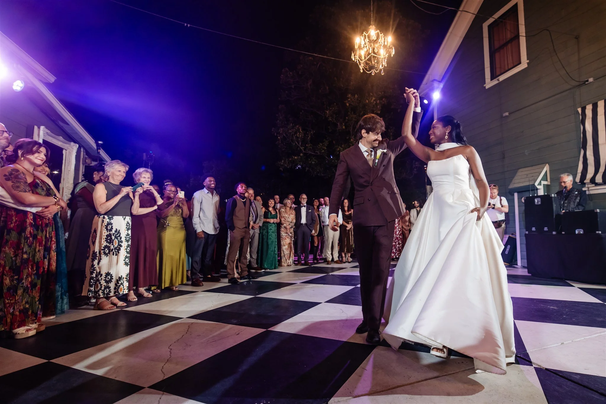 Couple sharing their first dance during an outdoor wedding reception at the Christmas House with the DJ providing music in the background