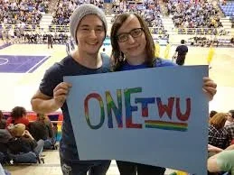Morgane Oger poses at a TWU volleyball match with a OneTWU advocate