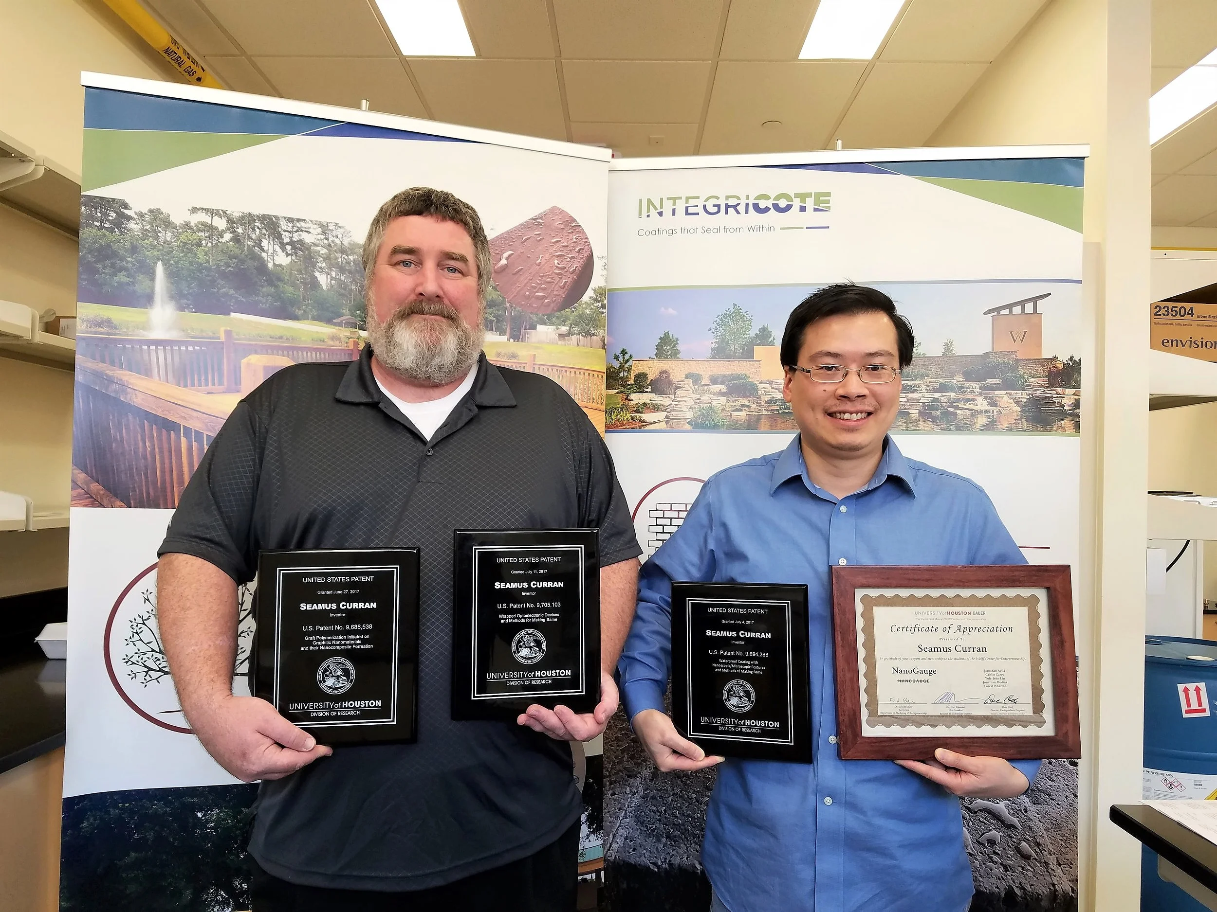 Integricote CEO, Prof. Shay Curran (left) and CTO, Dr. Shawn Liao (right) holding the patent awards.