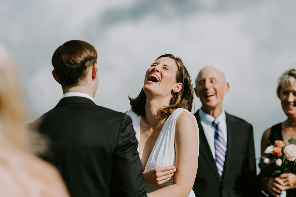 Bride laughing during ceremony. 