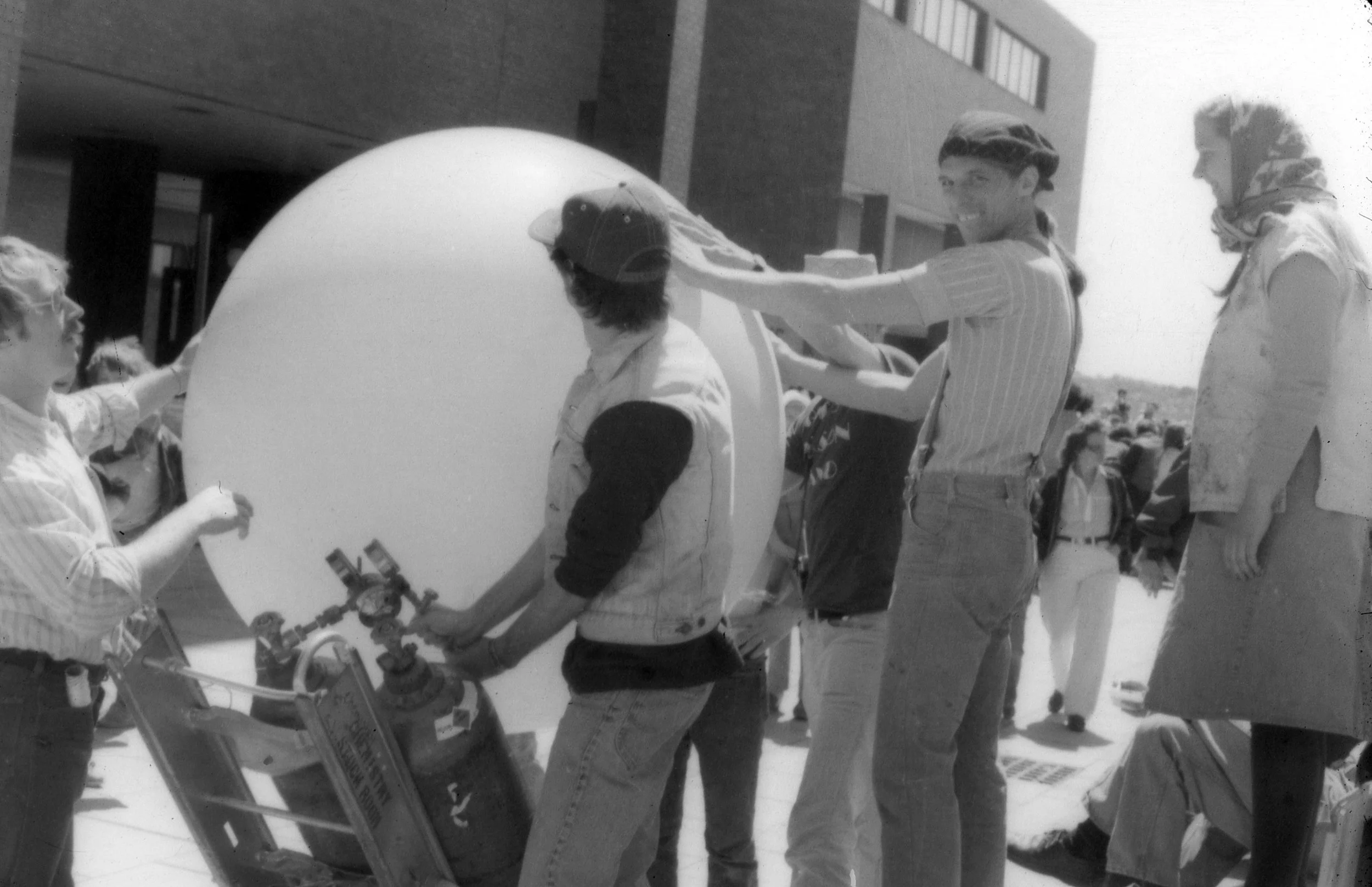 Poet Peter Payack with Steve Sharpe at Harbor fest, 1980, at University of Massachusetts, Boston inflating "Jupiter" a giant poetry balloon.