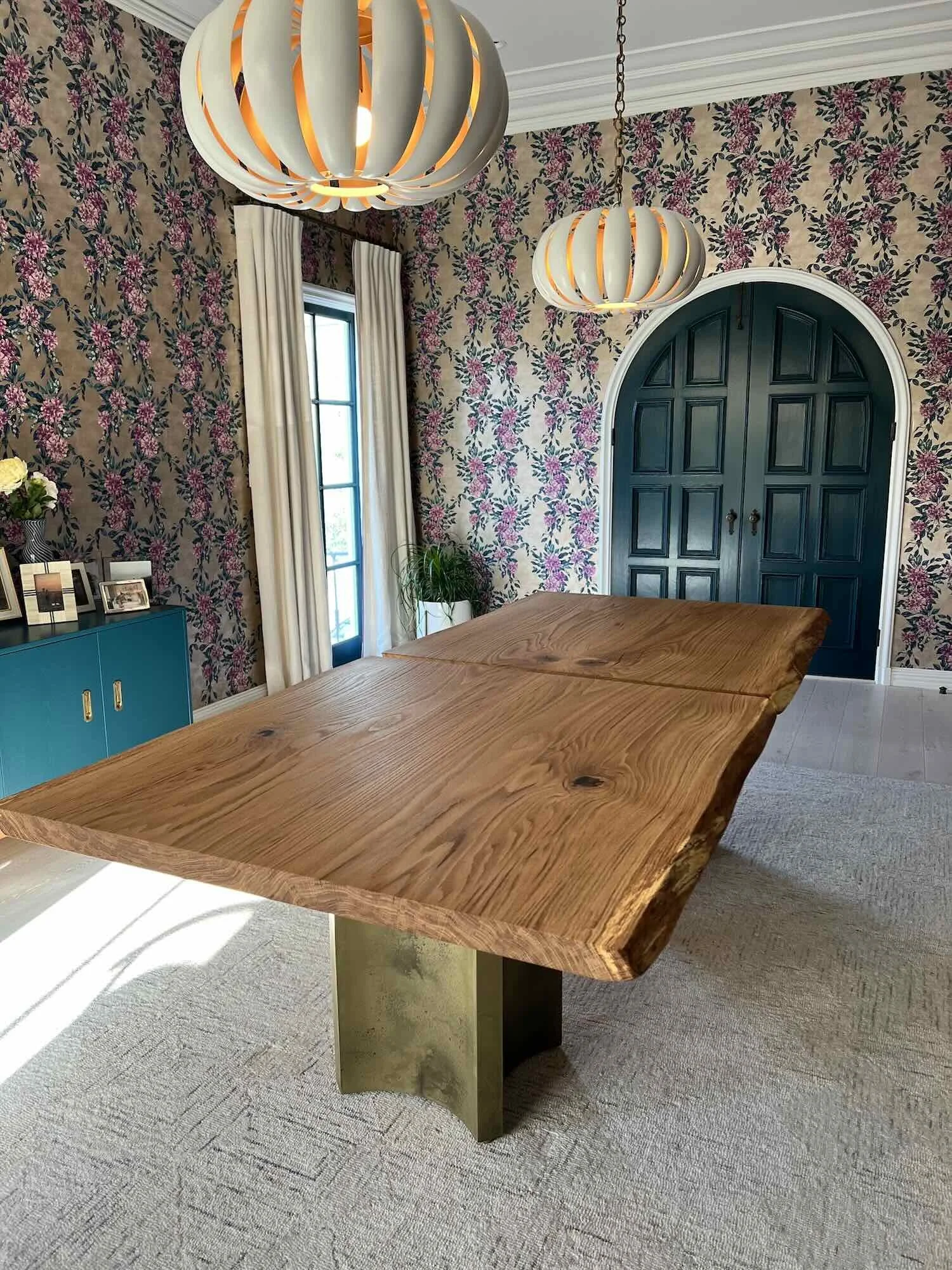 Handcrafted live edge white oak dining table featuring a sculptural brass pedestal base