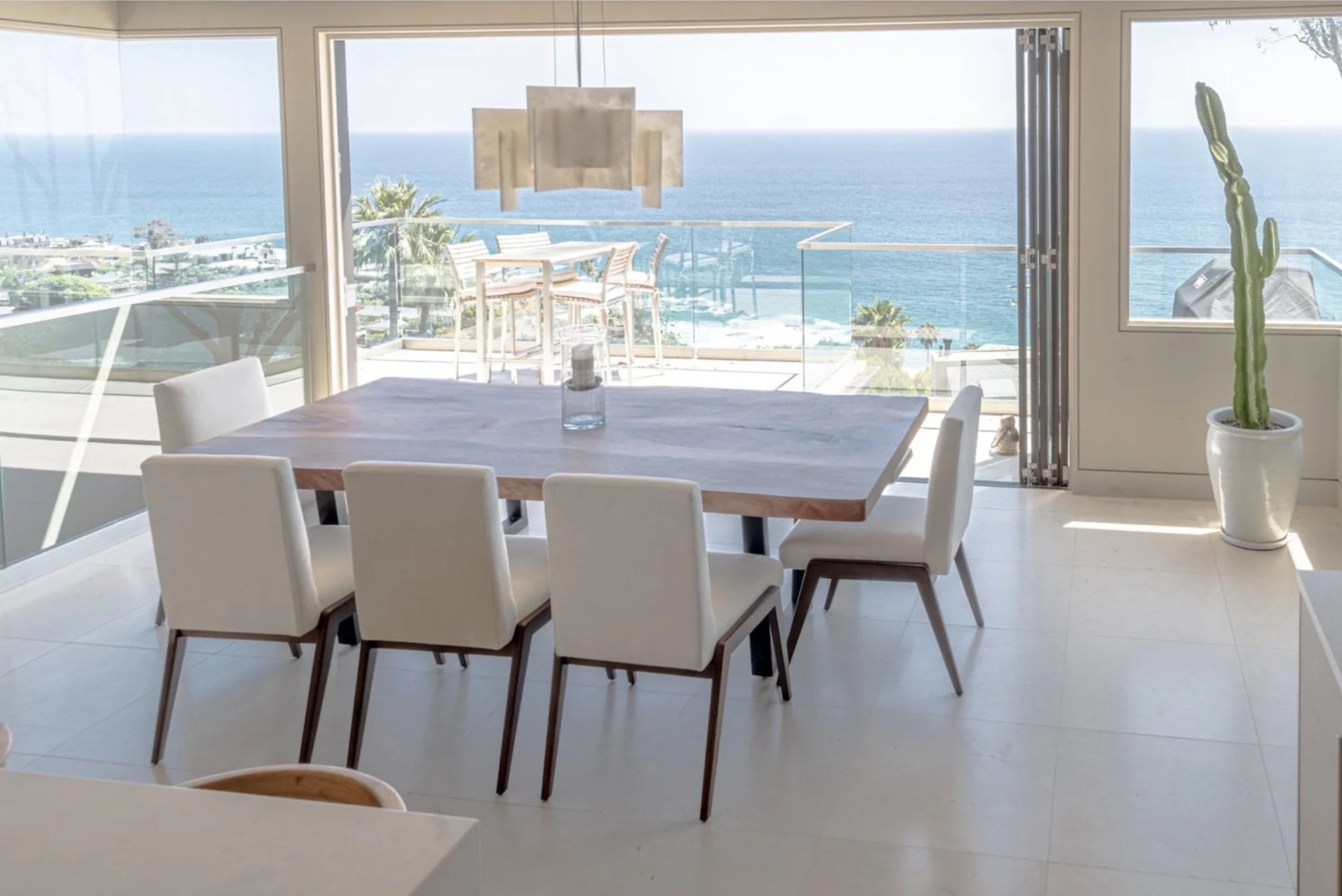 Custom handcrafted live edge walnut dining table finished with Rubio Monocoat hardwax oil in a luxury oceanfront home with floor-to-ceiling windows and panoramic Pacific Ocean views