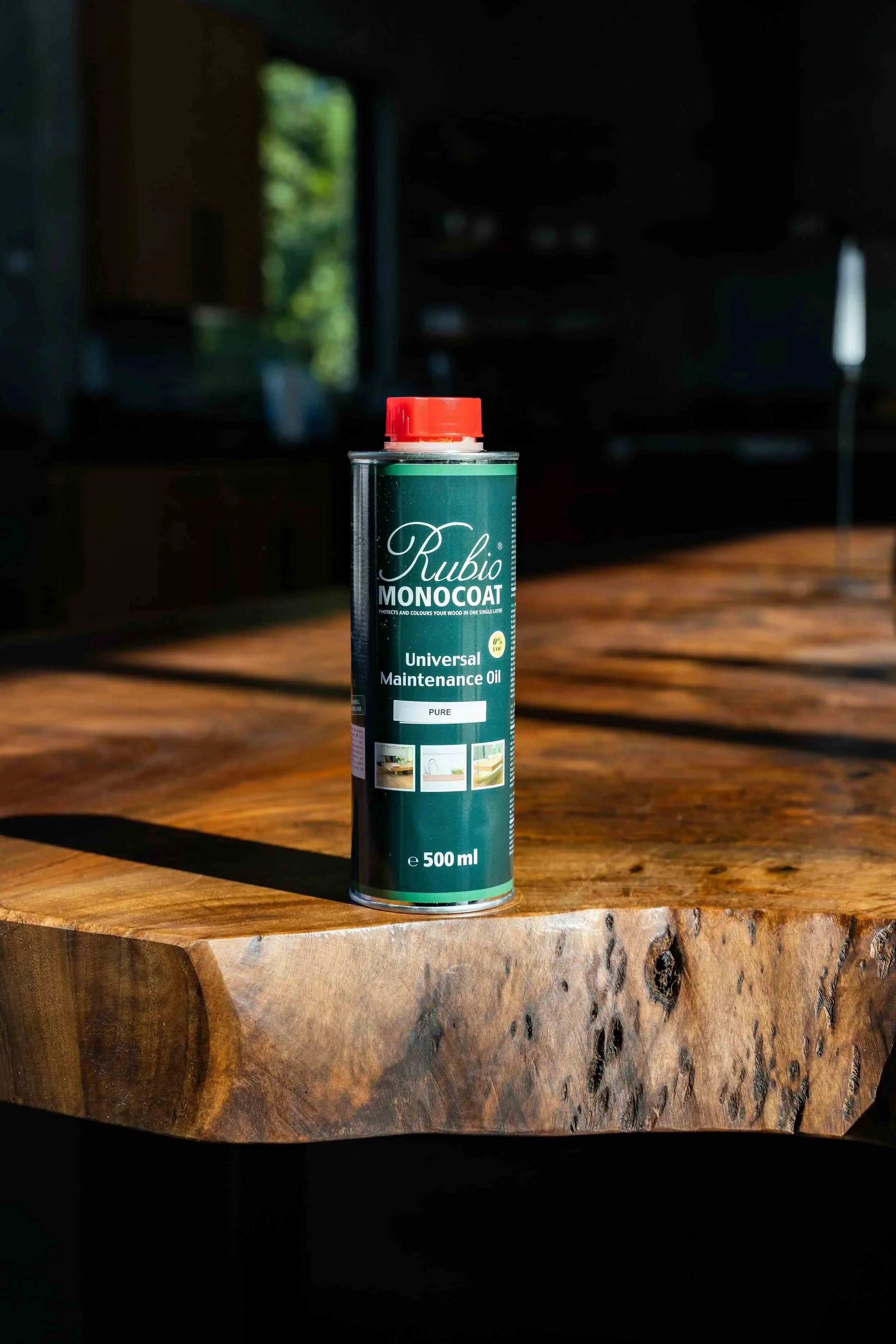 Rubio Monocoat Universal Maintenance Oil bottle on live edge wooden table, premium hardwax oil used for nourishing and maintaining custom live edge dining tables by Kristopher Kirkpatrick