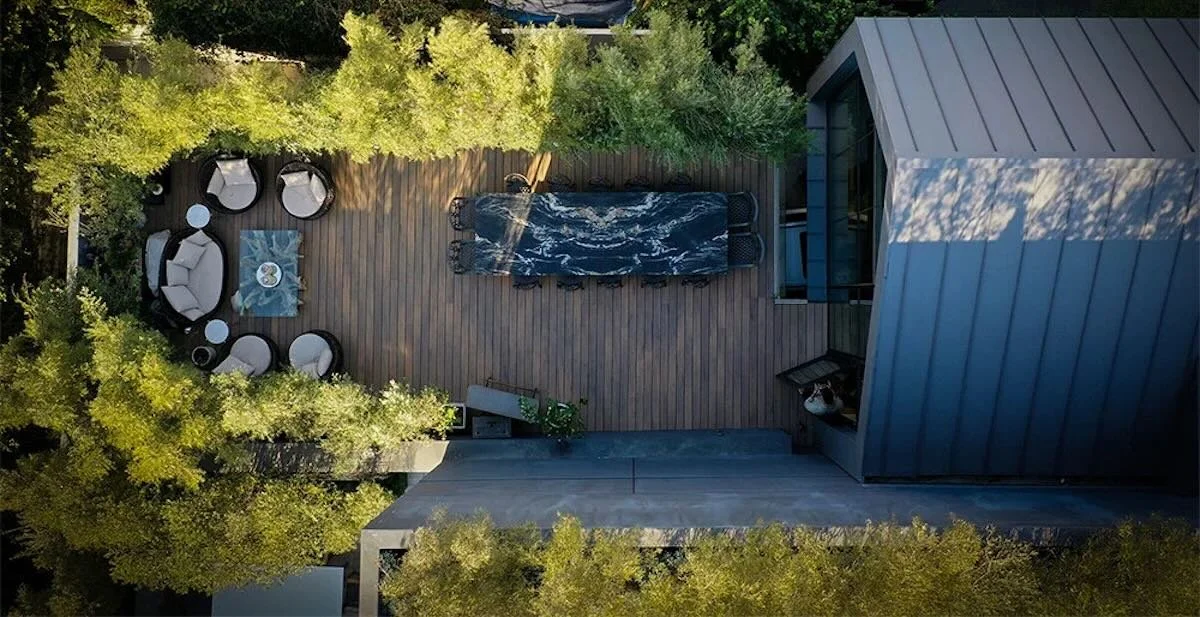 Full overhead view of live edge style quartzite stone patio table with matching chairs on a spacious modern deck