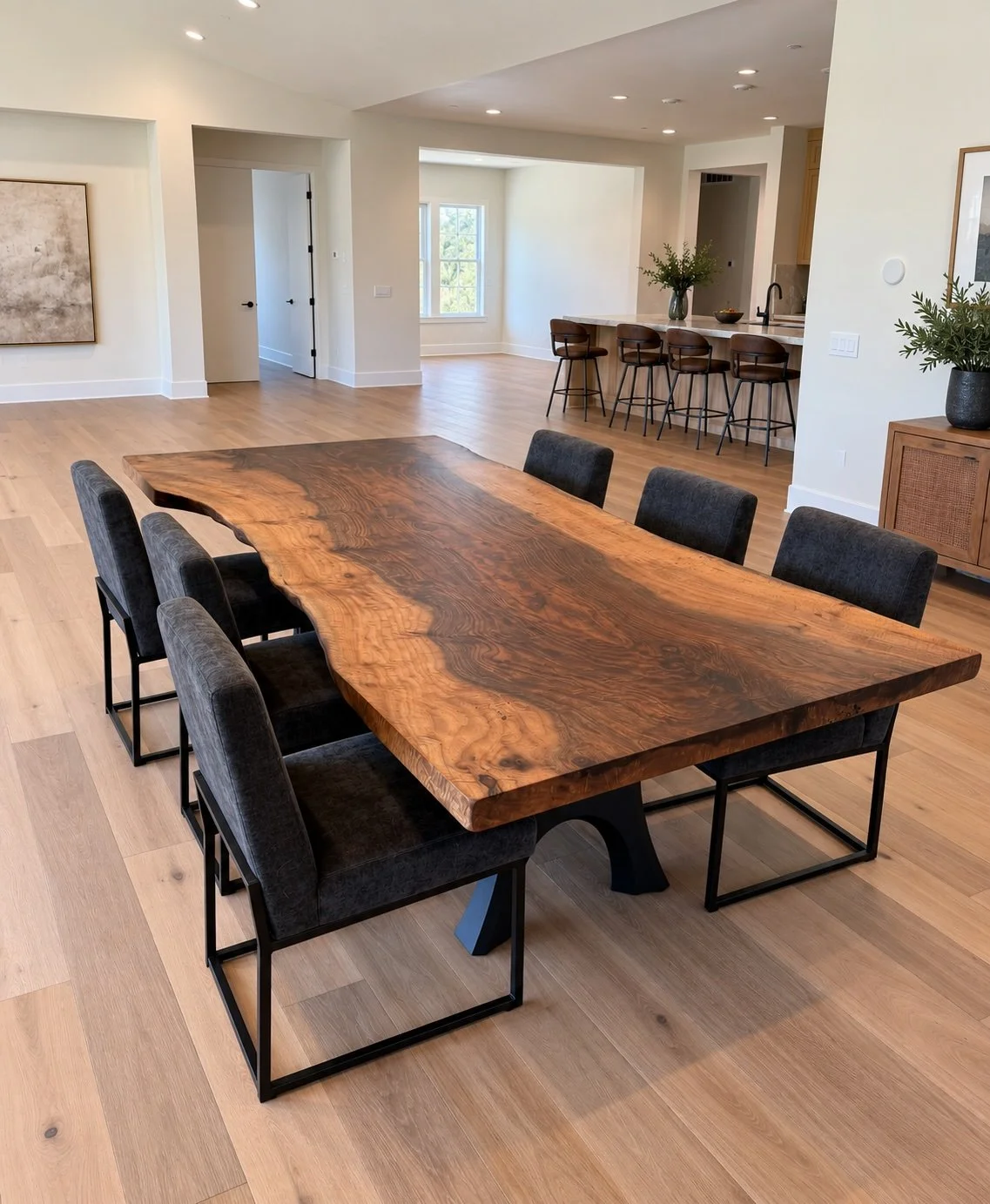 Custom single-slab walnut live edge dining table with dramatic natural grain and black metal base in a contemporary home