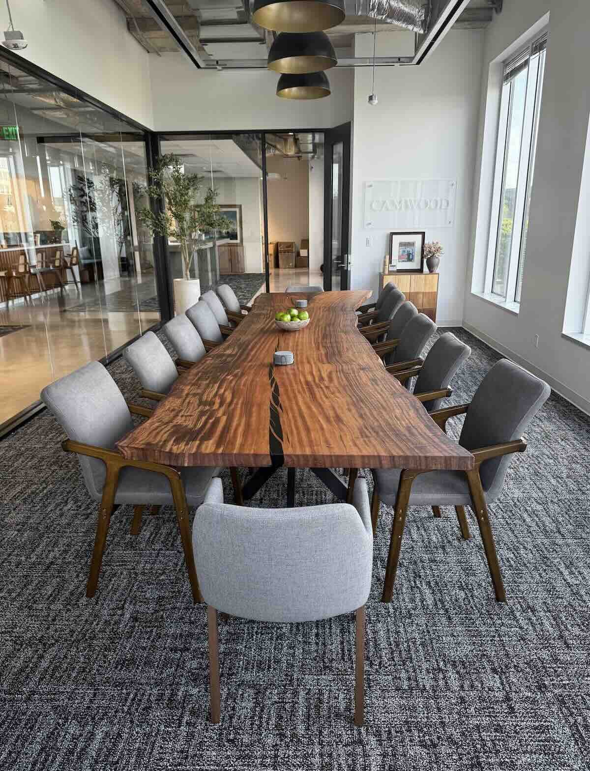 Custom Monkey Pod live edge conference table by Kristopher Kirkpatrick showing dramatic grain and live edges, styled in a contemporary San Diego office setting
