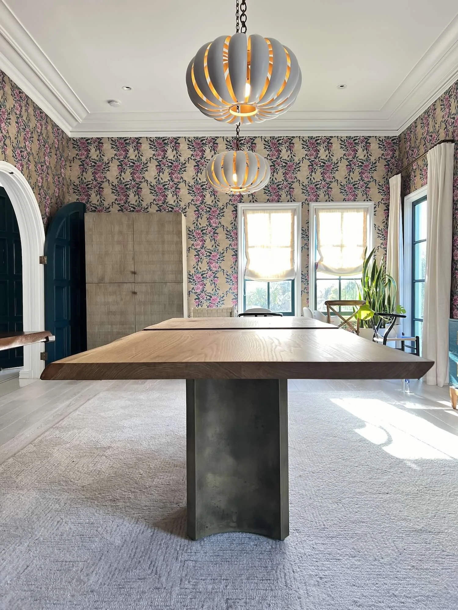 Handcrafted live edge white oak dining table featuring a sculptural brass pedestal base