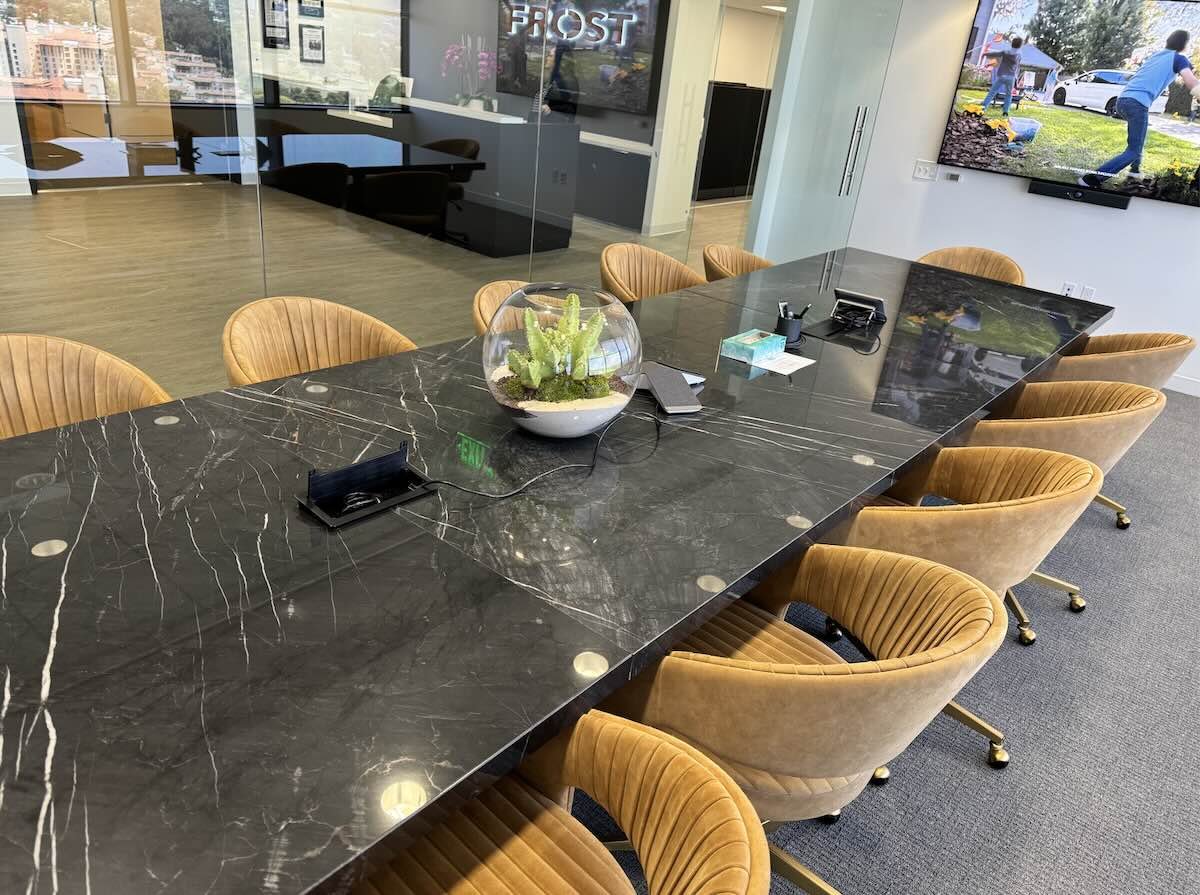 Black stone live edge conference table featuring smooth polished surface and built-in data ports for seamless business use