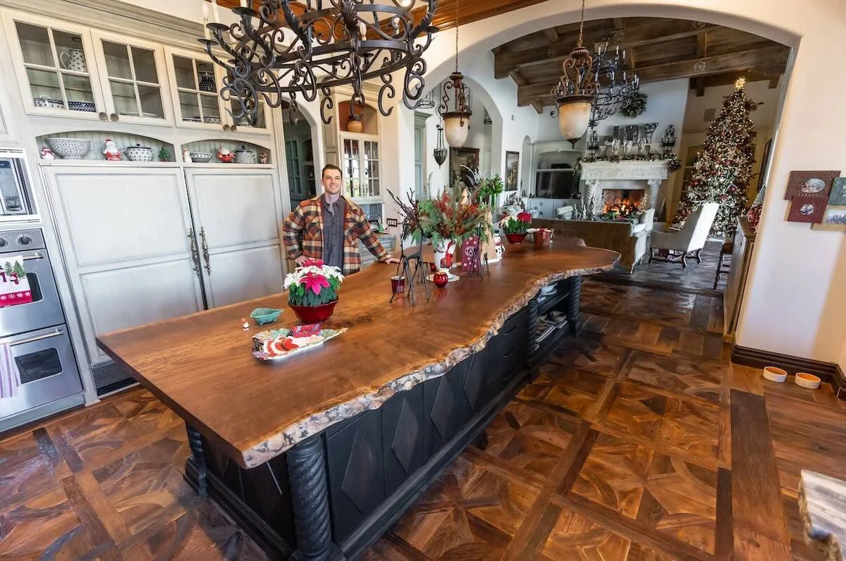 Large live edge walnut kitchen island with dramatic natural grain and thick slab top in a spacious custom kitchen