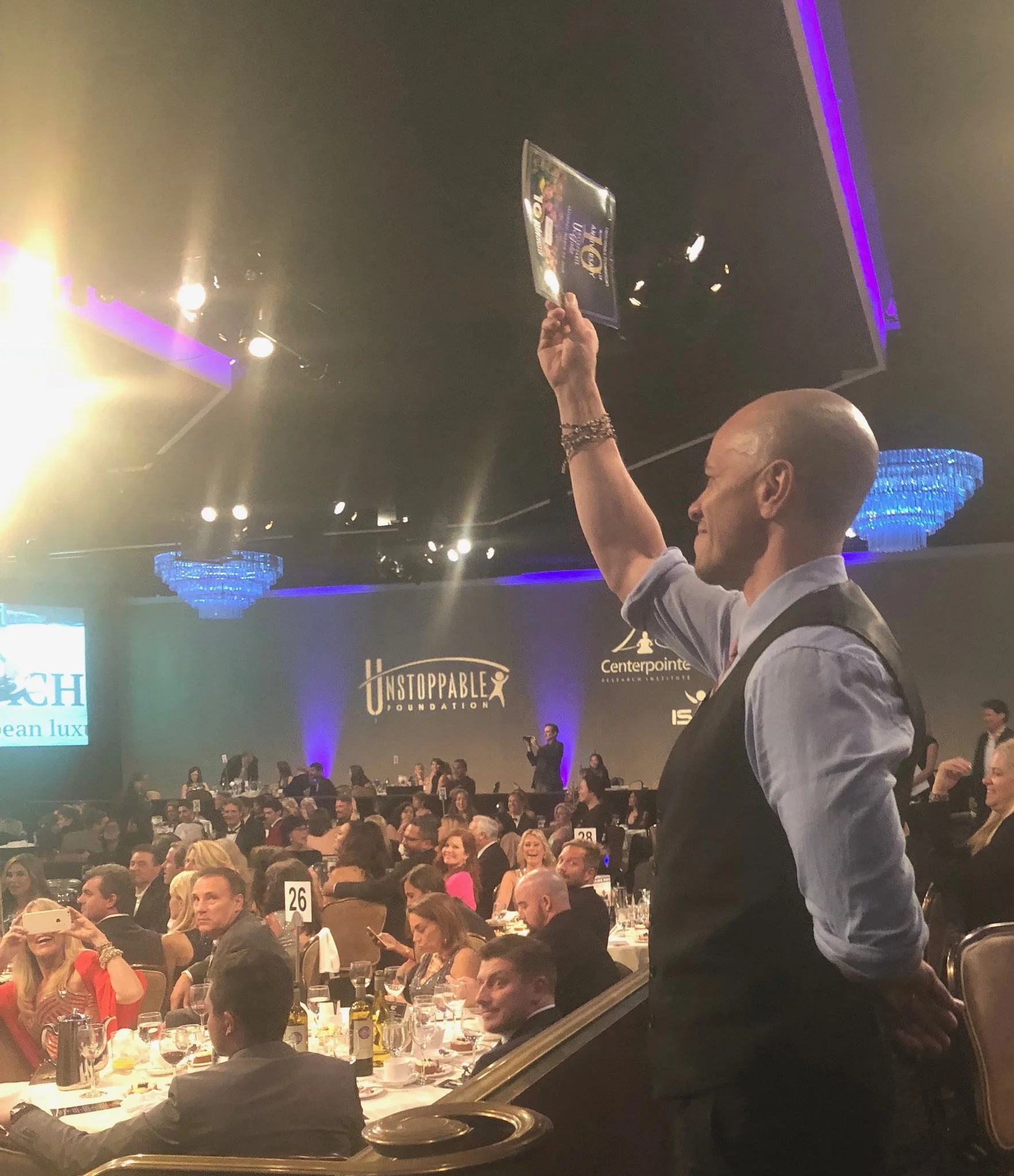 Guests eagerly raising their hands during the live auction