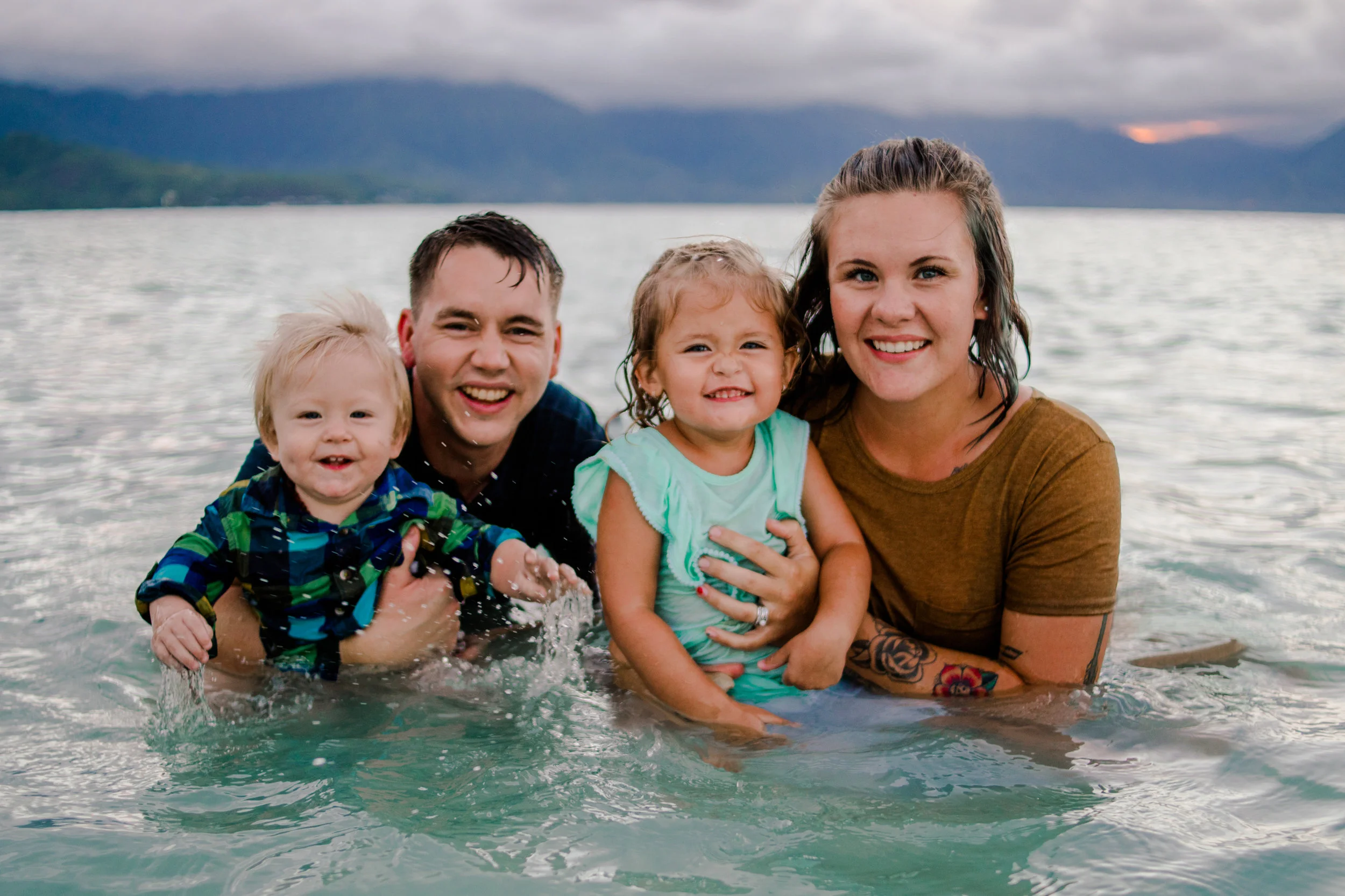 Oahu HI Family Photography, family sitting together in the water
