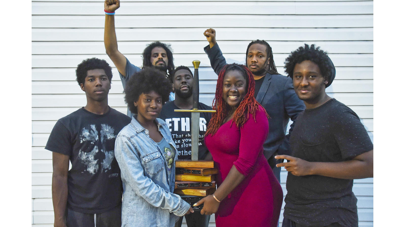 (Clockwise from left) Members of the youth and adult slam teams "Grim" Jackson, Slangston Hughes, Black Chakra, Kenneth Morrison, Deniero Black, Lady Brion, and MeccaMorphosis hold up the National Poetry Slam trophy. (J.M. Giordano/City Paper)