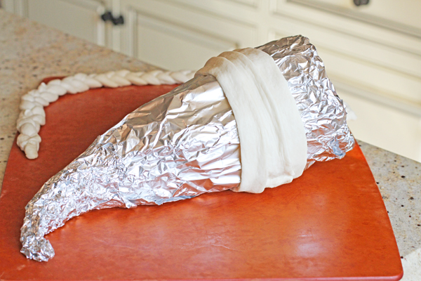 Keep wrapping the strips of dough until you completely cover the foil. And always remember to leave an inch of space at the top because it's easier to remove the foil once the bread is baked. Also a quick tip for all you perfectionists, try to cut your dough strips so all the seams meet at the bottom of the foil. This way, the ugliest part isn't seen : )