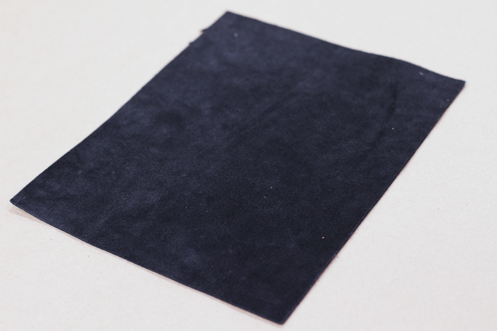 You want to start with an 8 1/2" x 11" piece of leather. You can get these exact size sheets at Michaels Craft Store or Joanne's Fabric. Flip the sheet over so the side you want to showcase is face to your surface. My suede side will be on the insid…