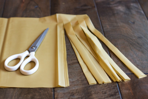 Using scissors, I cut one inch strips. Be sure to leave a 2" inch space on top. You do not want to cut the strips off. Leave them attached.
