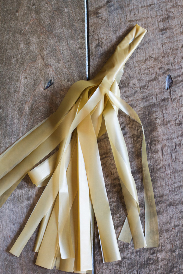 And staple the top so your fringe tassel now looks like a pom pom.