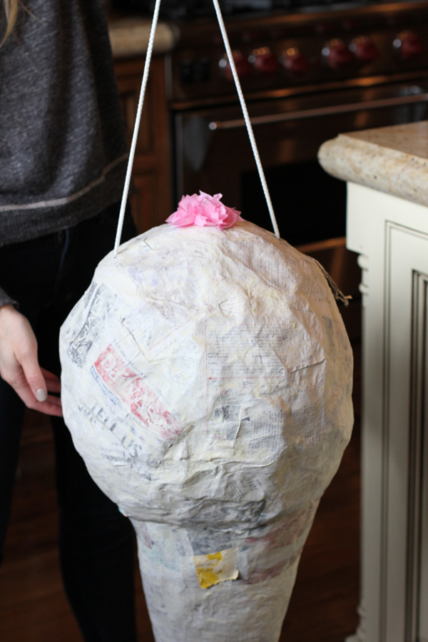 And I completed it. Six days later my piñata is dry and ready to go! This is when you need to put your rope through the piñata. Cut two holes on the sides of your piñata and string a heavy rope right through it. Make sure your holes are far enough apart. I ended up putting so much candy in my piñata that it got too heavy and I had to take the rope out and tie it around the actual cone itself. When you cut your holes your balloon should pop and just fall to the bottom of your cone.