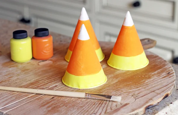 Paint your hats with orange and yellow paint. Eyeball it or use a pencil to draw a straight line around the hat - this is super simple. The white part is the actual paper cone. I did not use white paint. Let your little hats dry.