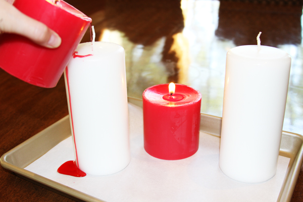 Place your candles on a piece of paper so the wax doesn't get onto any other surface. Now light your red candle (a taper candle works extremely well .... I just didn't have one) and let the flame go for about a minute until you have a small puddle of wax. Tip the red candle and pour the red wax onto the edge of the white candle. Just leave the candle lit as you drip the red wax around the white candle.