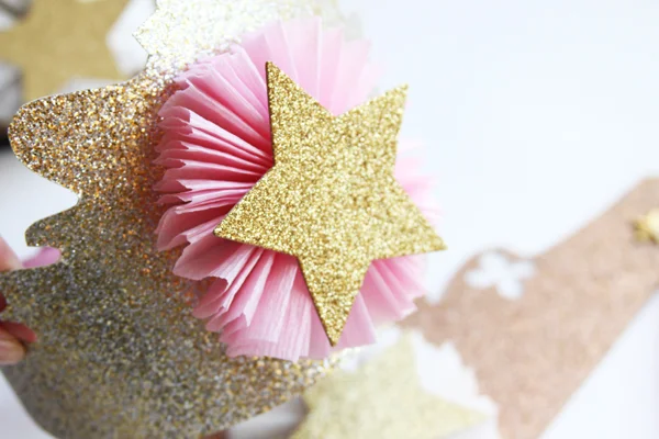 Next you want to add your star. Again, this step is optional. On some of my crowns I use glitter numbers. If I am giving one to someone for their first birthday I will put a ONE in the middle or their first initial. They sell already die cut glitter numbers and letters at Michaels. They also have pre-done stars that come in a package of 20.