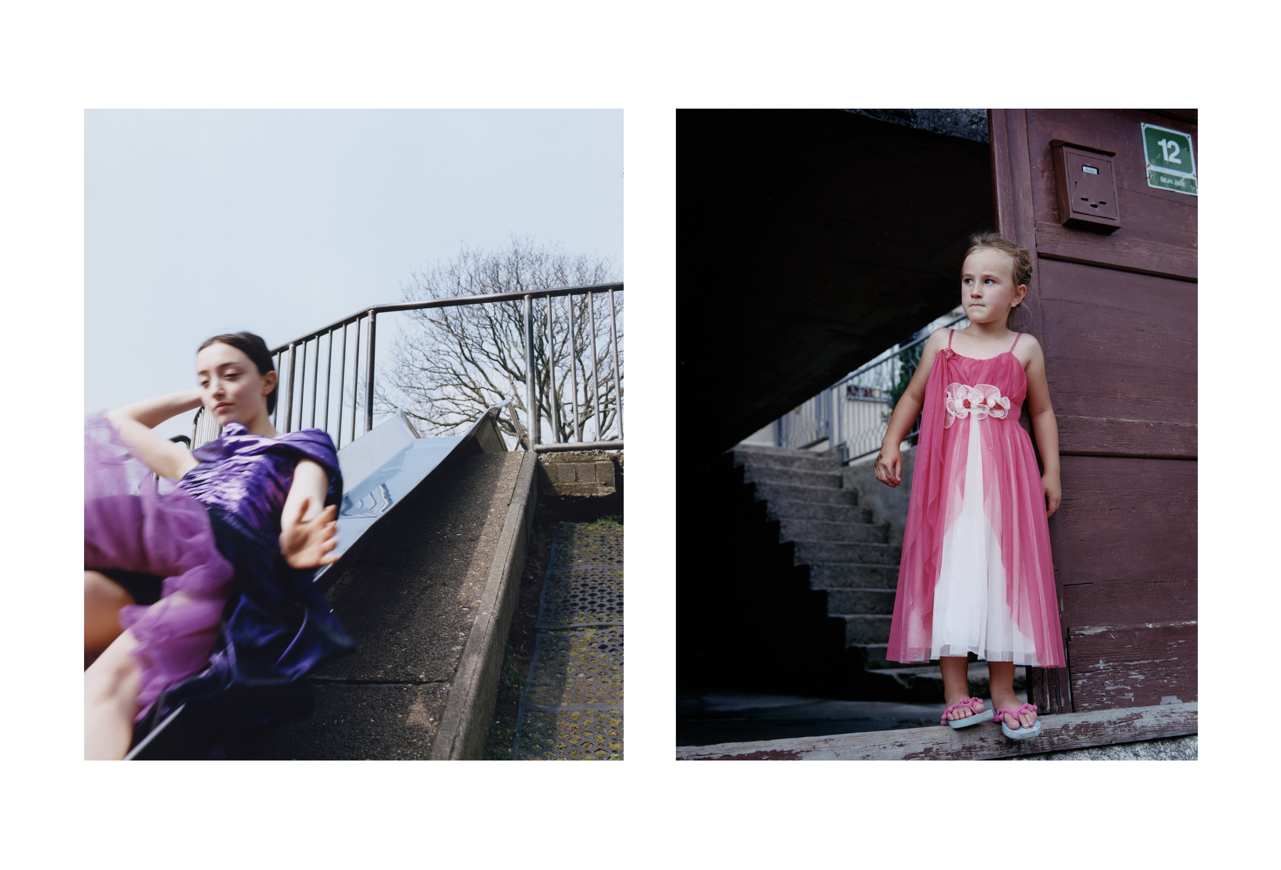 Two girls in fancy dresses, one in purple and the other in pink, standing outdoors near a staircase and a wooden building.