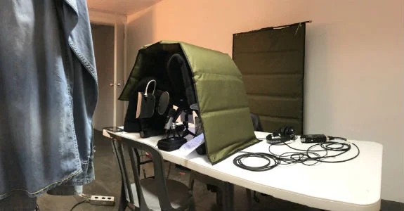 “Cabine com mantas acústicas em cima de uma mesa no camarim dos artistas”