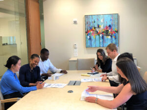 Junior professionals pose before a meeting in a conference room of Palladium Equity Partners
