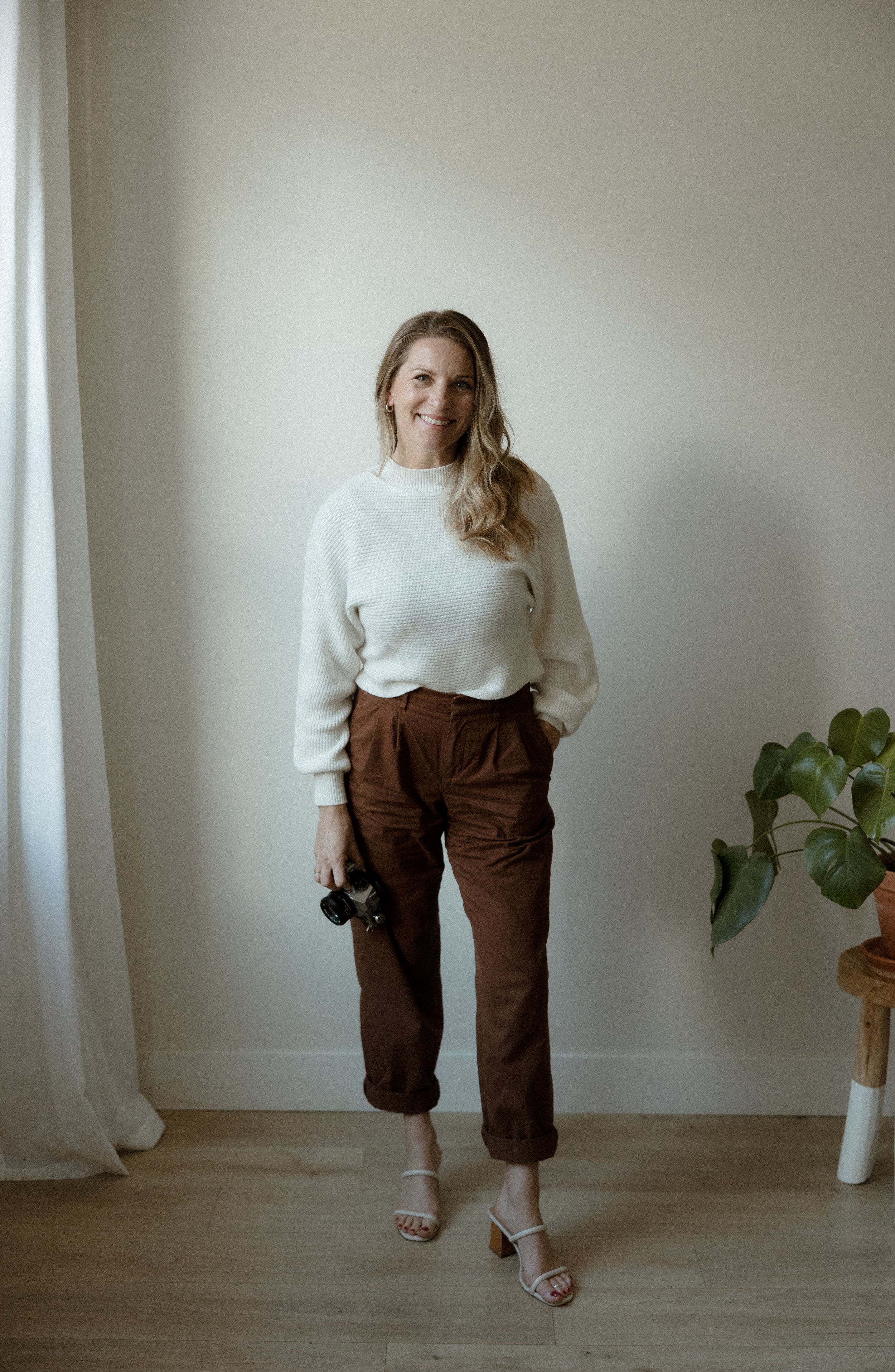 woman standing with a camera for a headshot