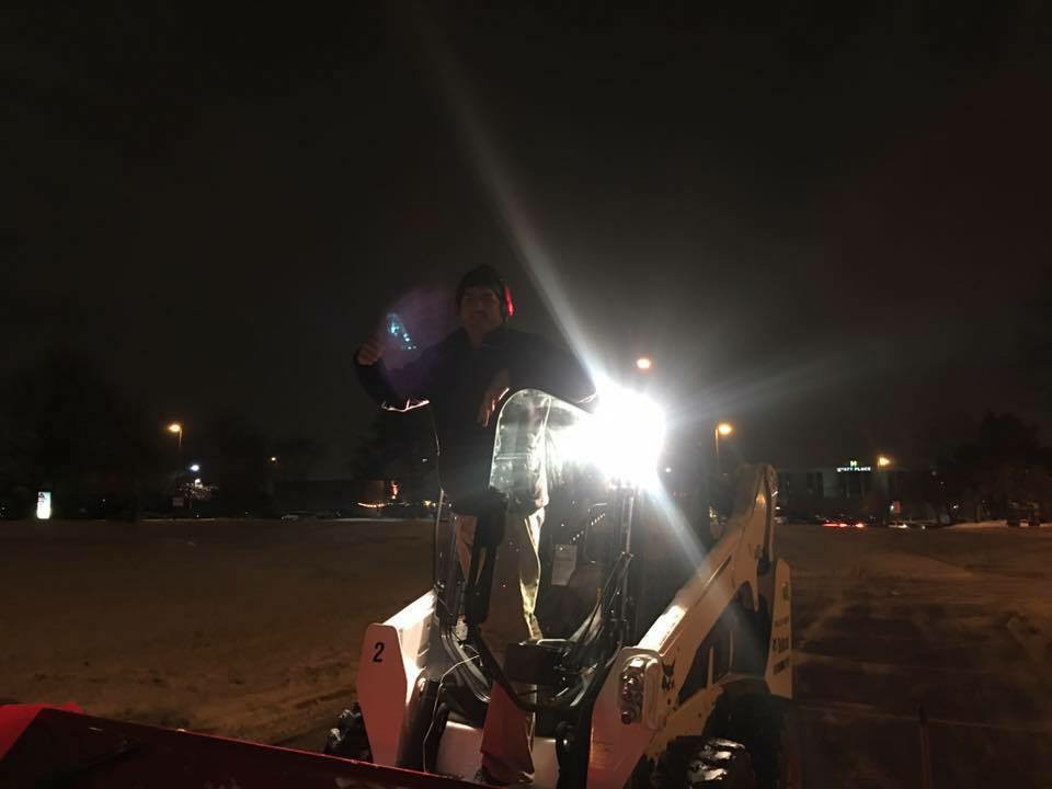 Night time snow removal with bobcat by Columbus Landscaping company.