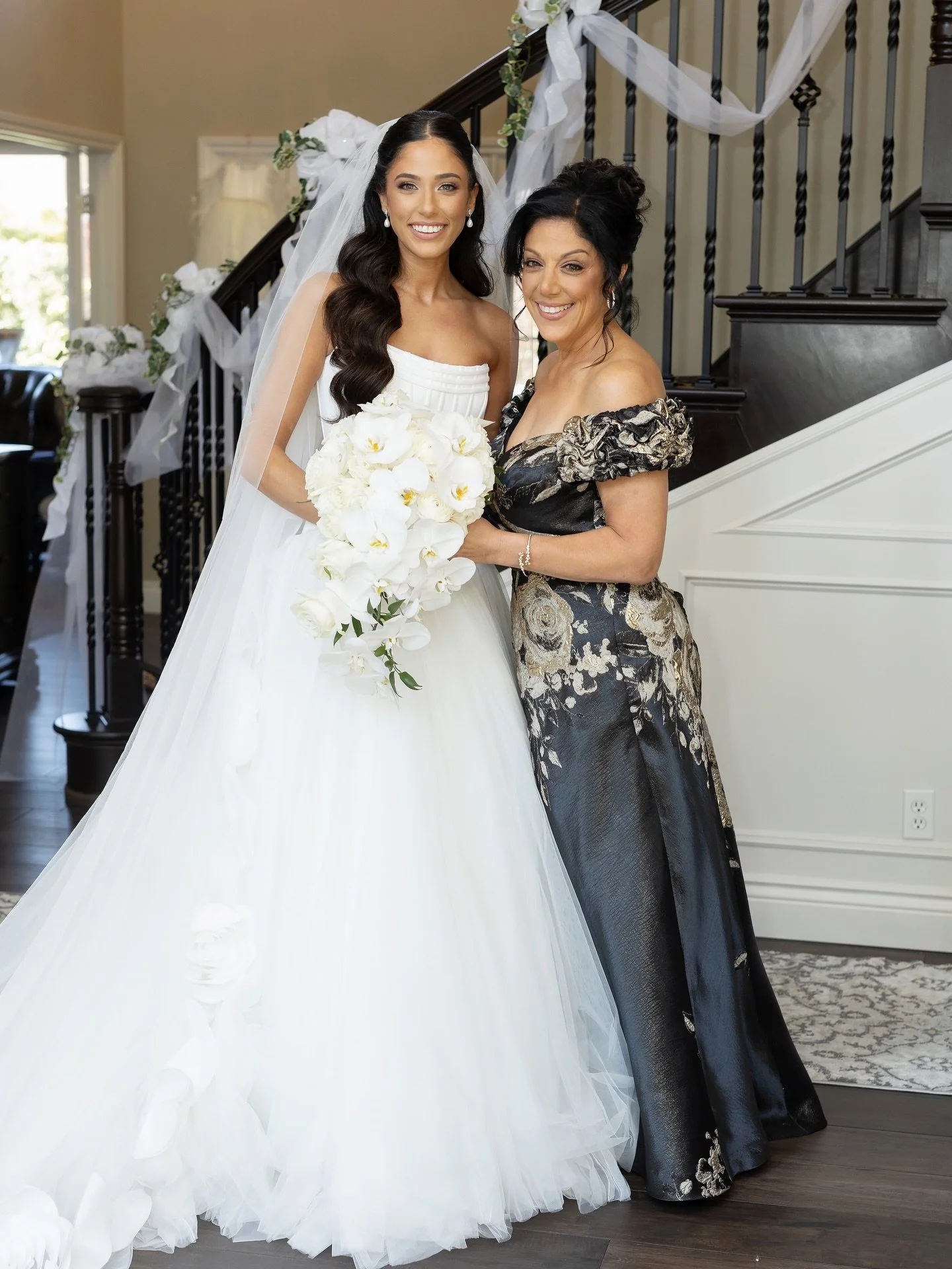 Last week we shared photos of our beautiful bride &amp; Piera&rsquo;s newest granddaughter-in-law, Angela. This week we are shouting out her beautiful Moms 🤍 
&bull;
Angela&rsquo;s mom Stephanie wore a gorgeous black and gold a-line gown by @terijon