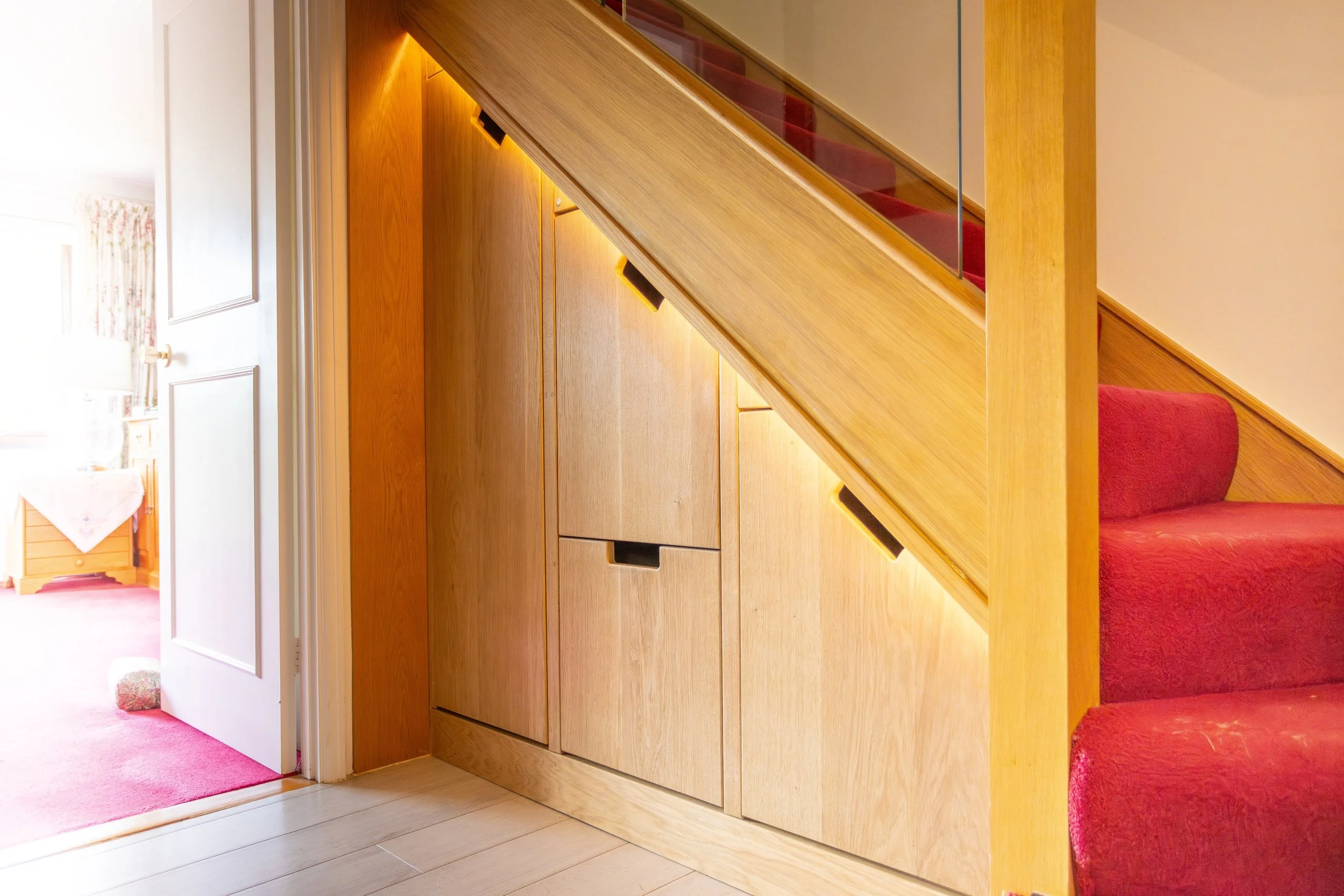 Drawer Chest under the stairs of a modern home. In oak veneer and solid oak
