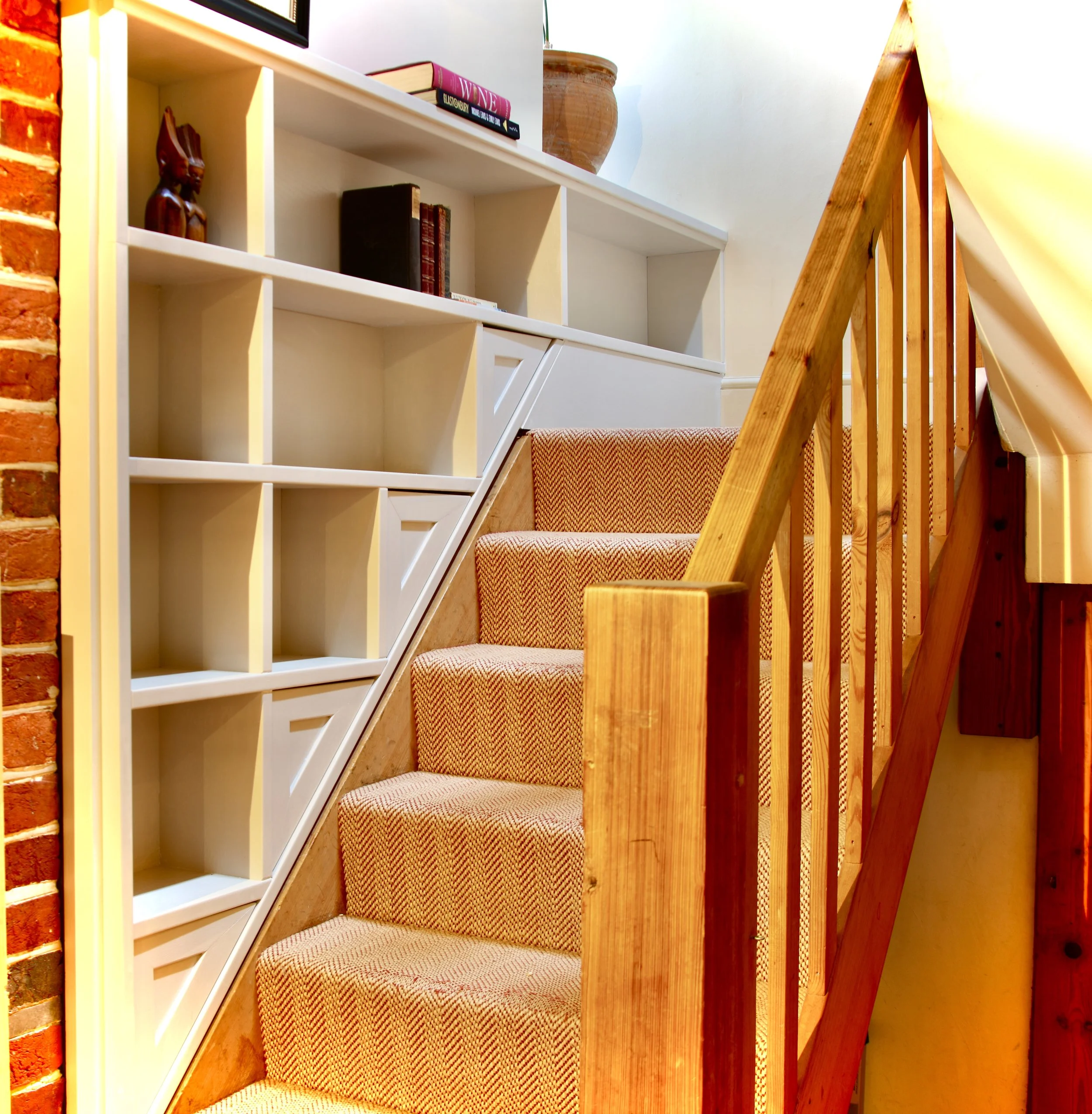 Painted oak-veneered under-stair shelves with natural wood grain effect