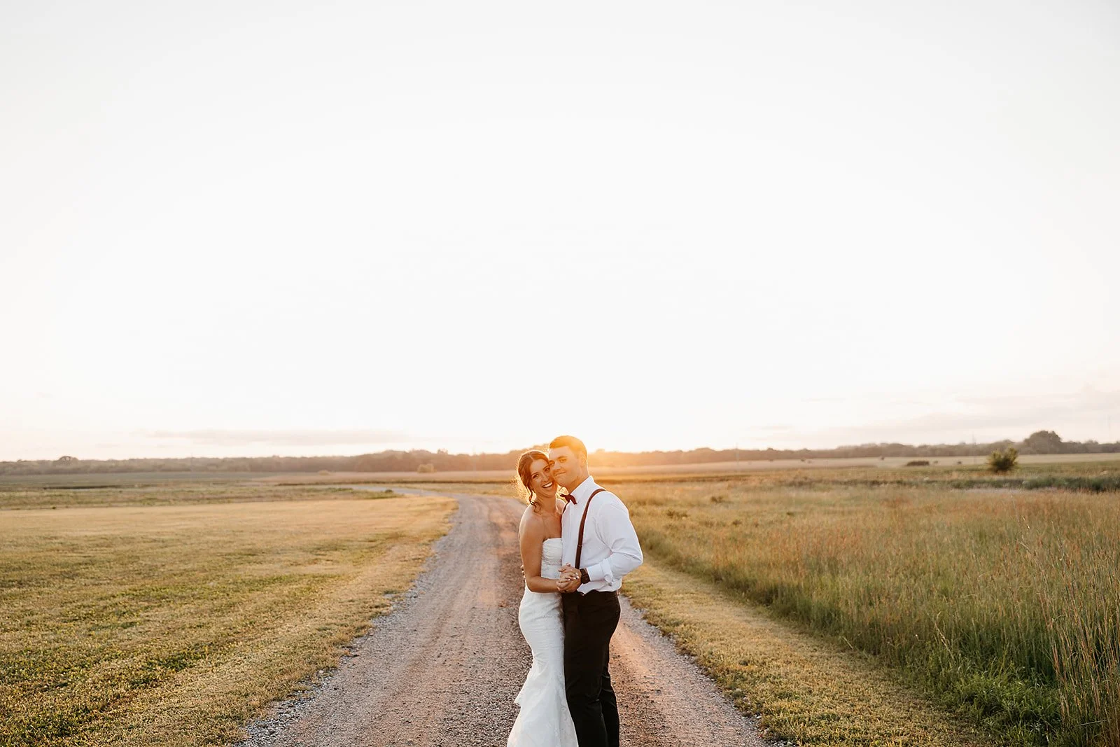 bride and groom enjoying sunset photos in the kansas country