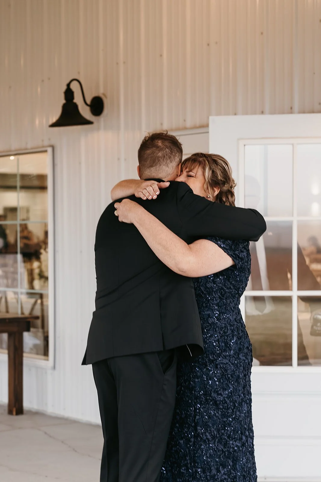 groom seeing his mom for the first time and hugging on the patio