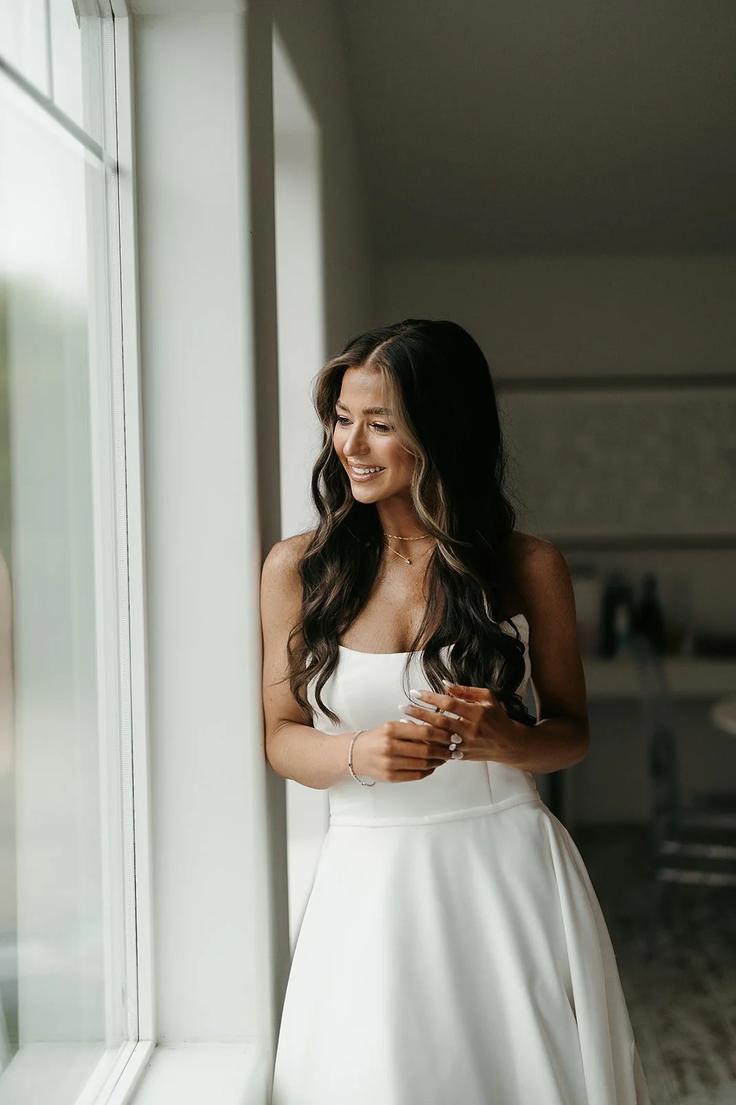 bride peering out the window on a rainy day