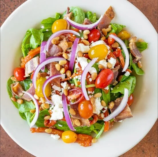A plate full of green salad from Amici’s Pizzeria.