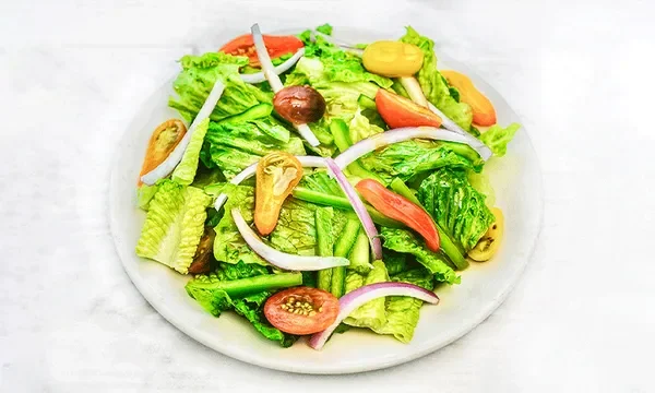 Amici’s Garden Salad with crisp romaine, lettuce, red onion, and tomato.