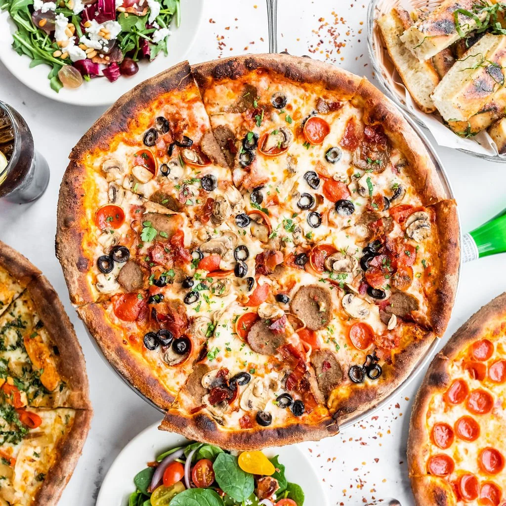 Loaded combo pizza with olives, mushrooms, and tomatoes served with fresh salads from Amici’s East Coast Pizzeria