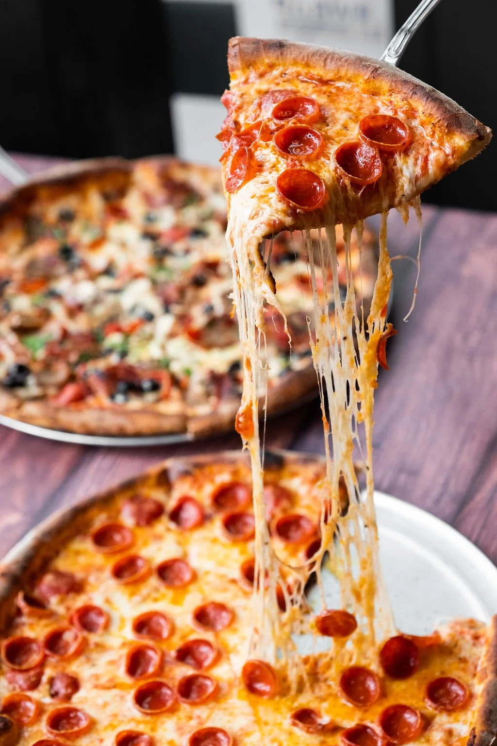 Charred pepperoni pizza from Amici’s with melted cheese and crisp crust served on a restaurant table.