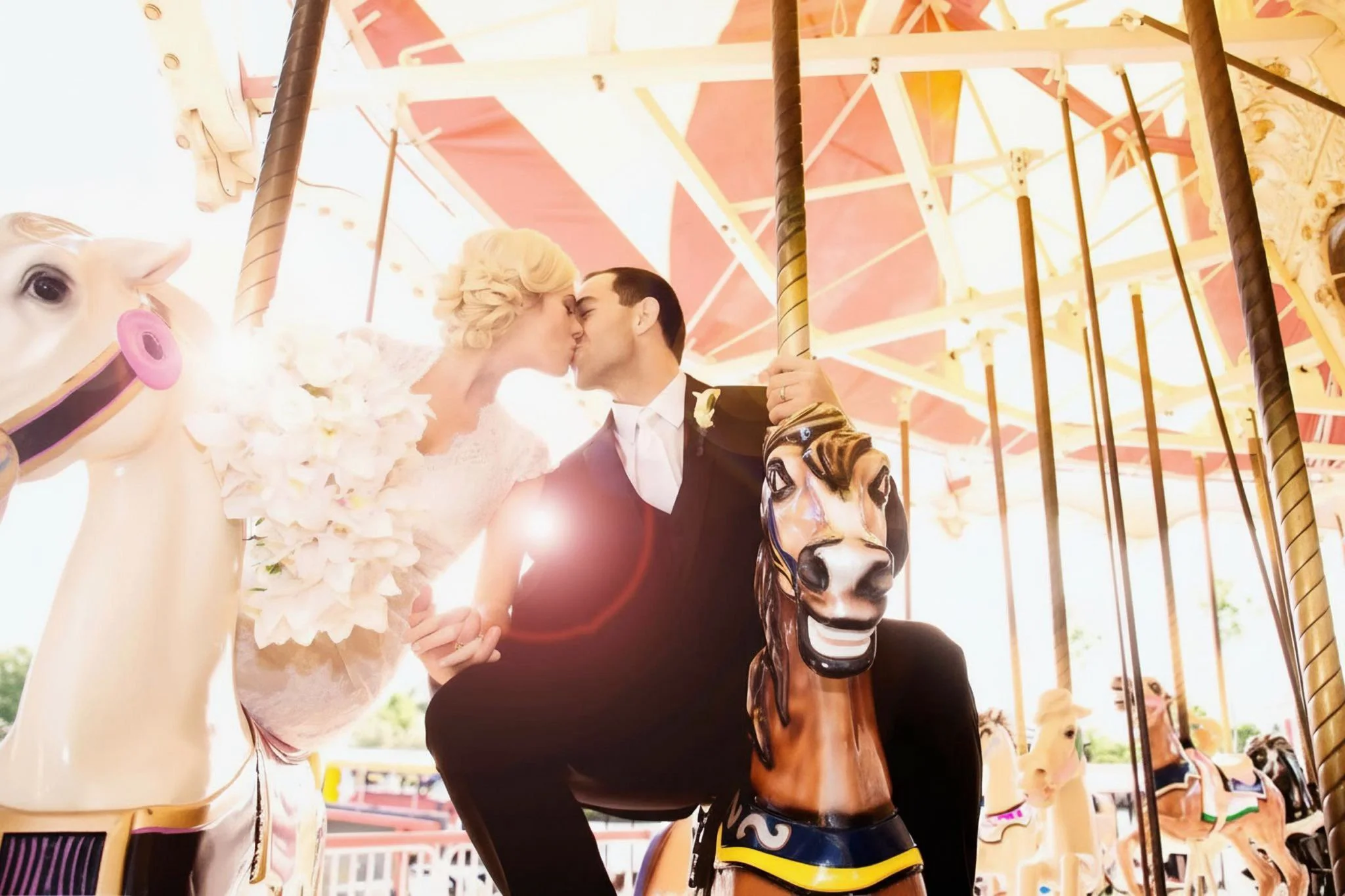 Omaha Wedding Photographer | Bride and Groom Kissing on Carousel | Destination Wedding 