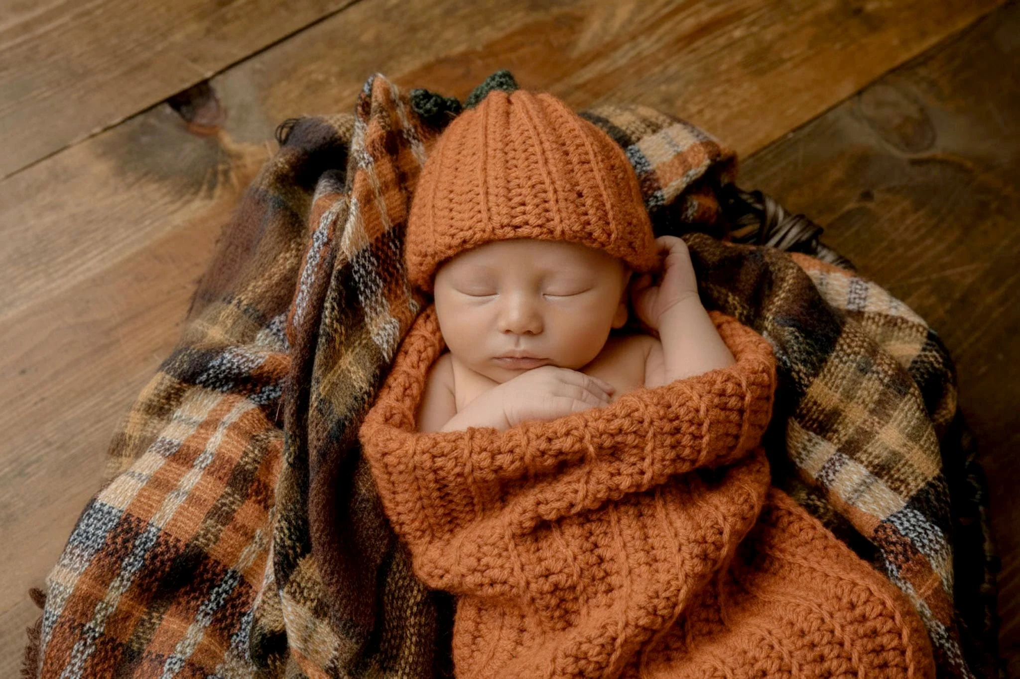 Omaha Newborn Photographer baby boy in pumpkin hat and fall blanket 