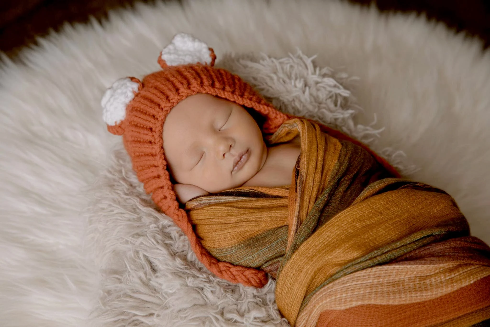 Omaha Newborn Photographer sleeping baby boy in fox crochet hat and wrapped in fall colors 