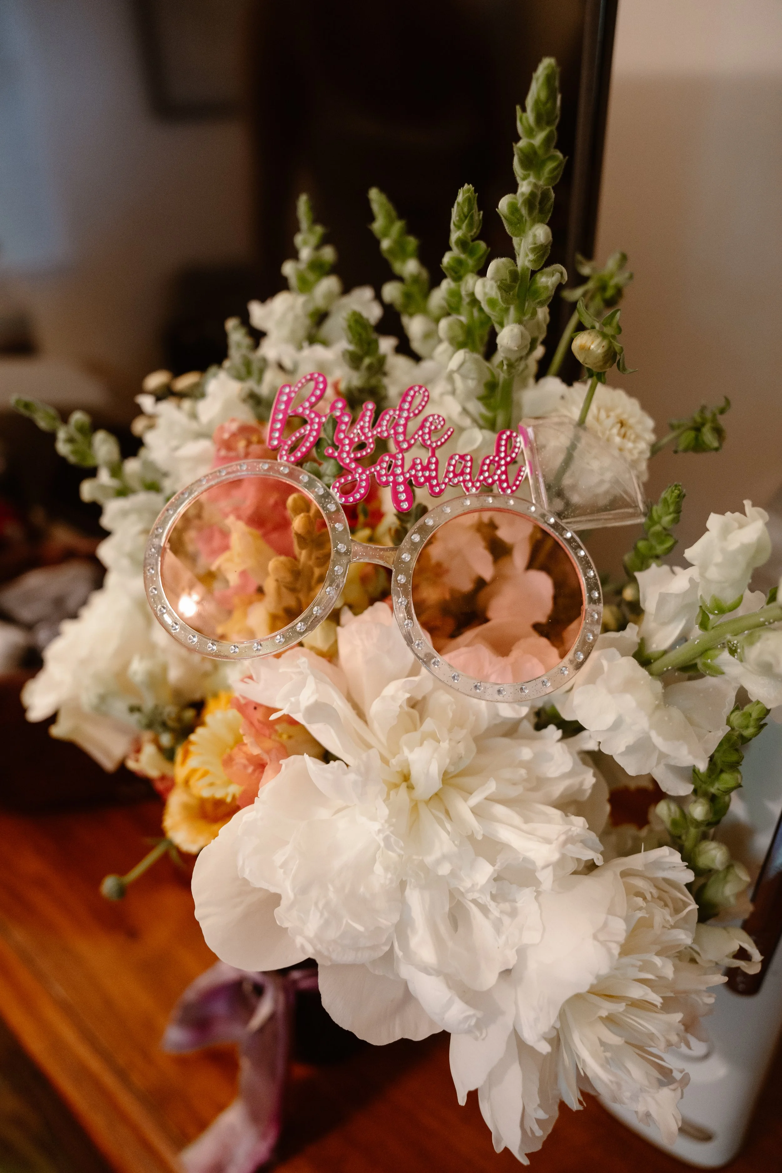 A beautiful bridal bouquet with silly "Bridesquad sunglasses"