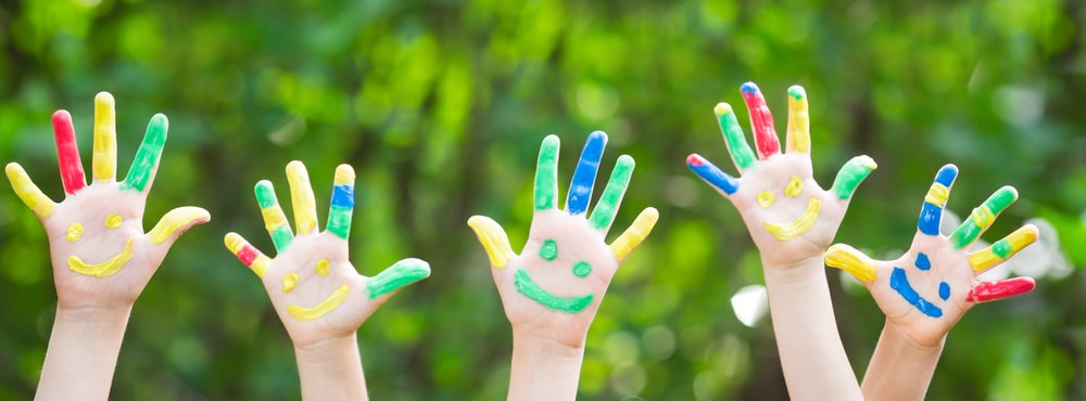 Kids painted hands featuring smiley faces