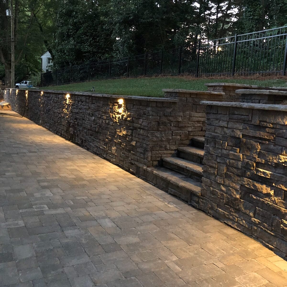 This retaining wall replacement project was an existing brick wall that had failed due to a lack of drainage behind the wall. The project included; New engineered Heritage block retaining wall, Belgard paver patio, bringing everything up to code, mak